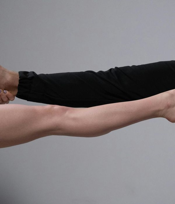Man performing a strength and balance exercise in a bright studio.